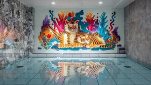 A lobby with a large mural of a tiger surrounded by colorful flora. - Hotel Plumm (Yokohama)