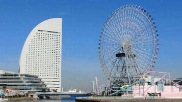A waterfront view with a large Ferris wheel and modern buildings.