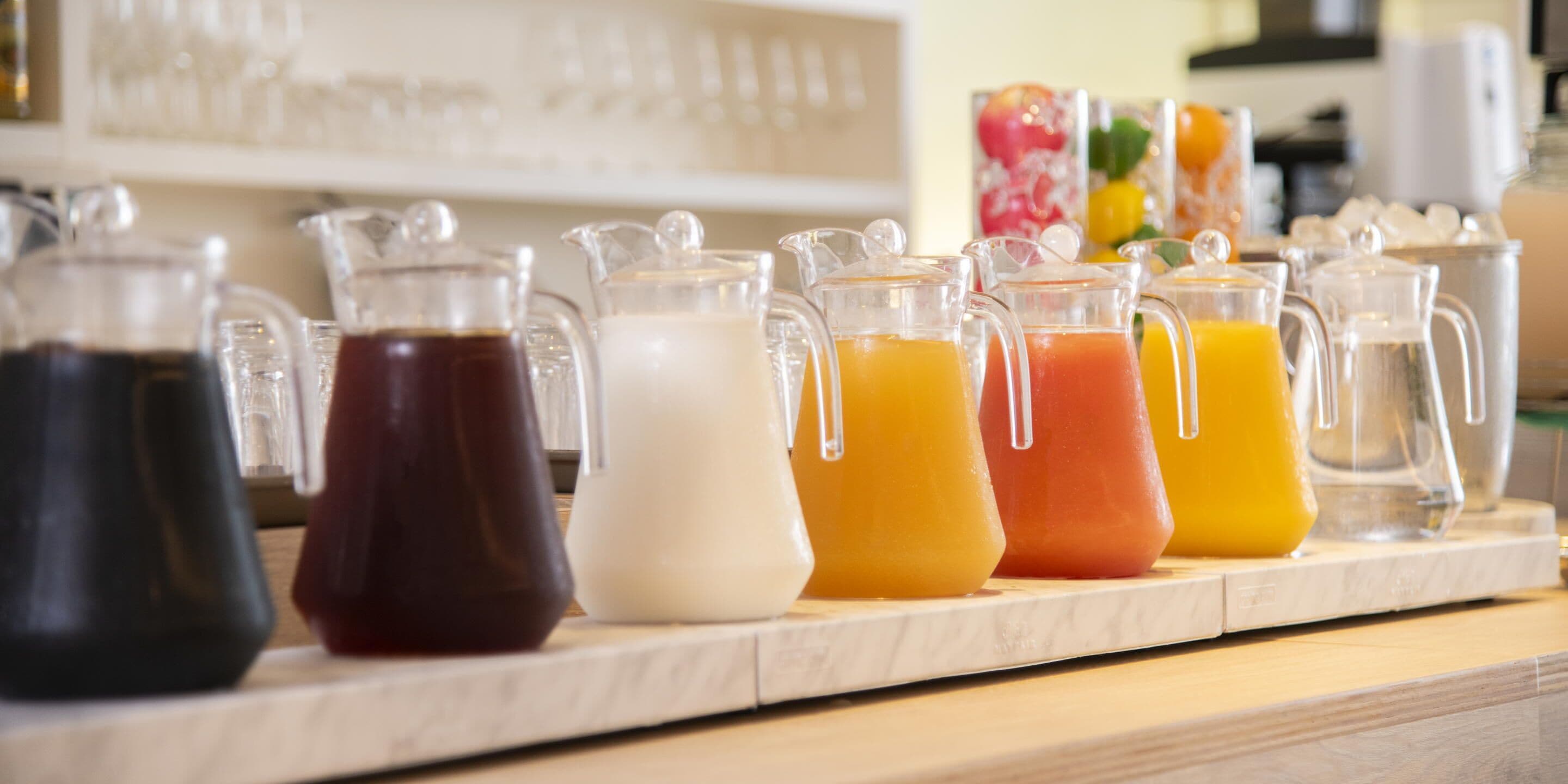Una encimera con varios jarrones que contienen bebidas de distintos colores.