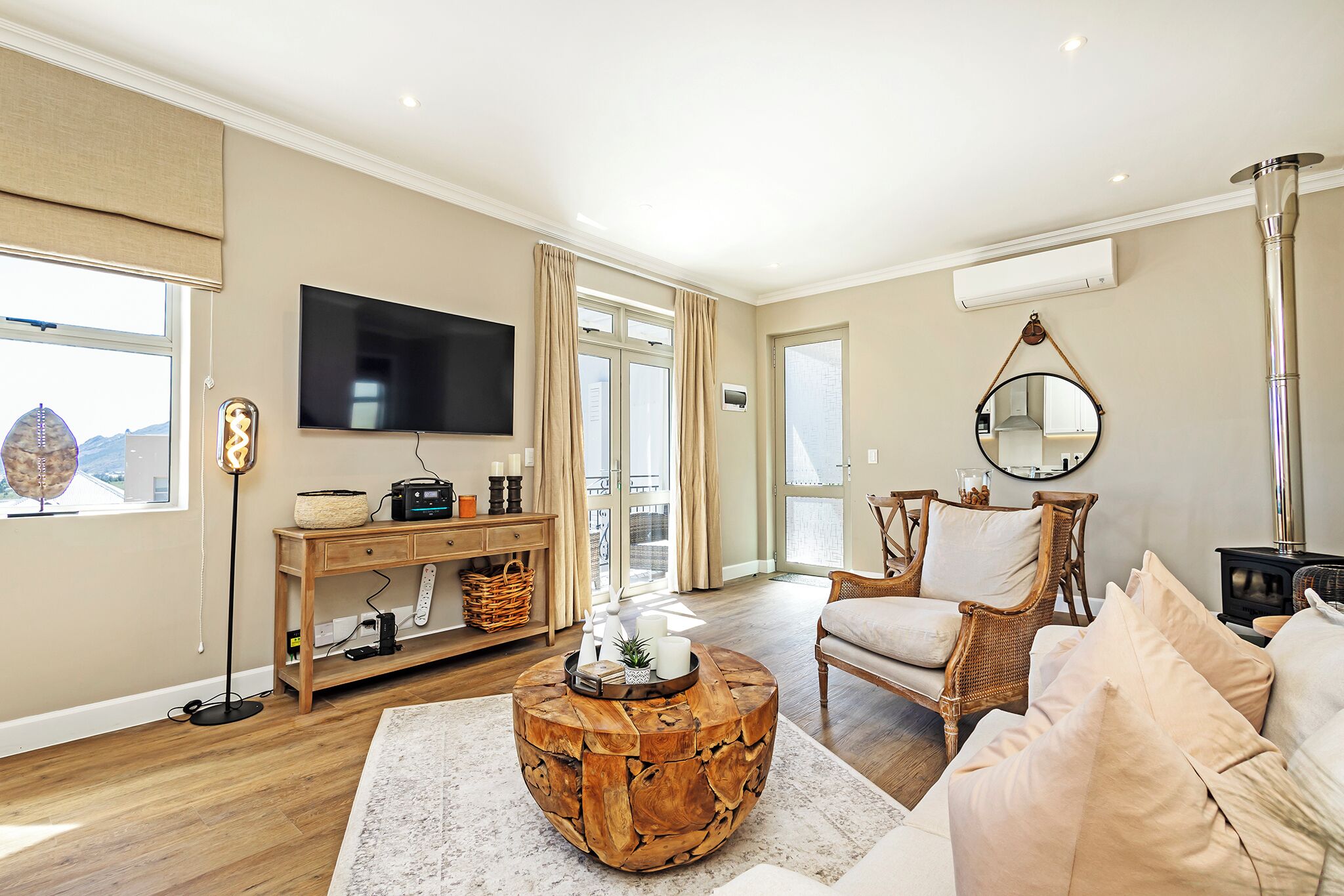 A living room with a round wooden coffee table, a sofa, a television, and a fireplace.