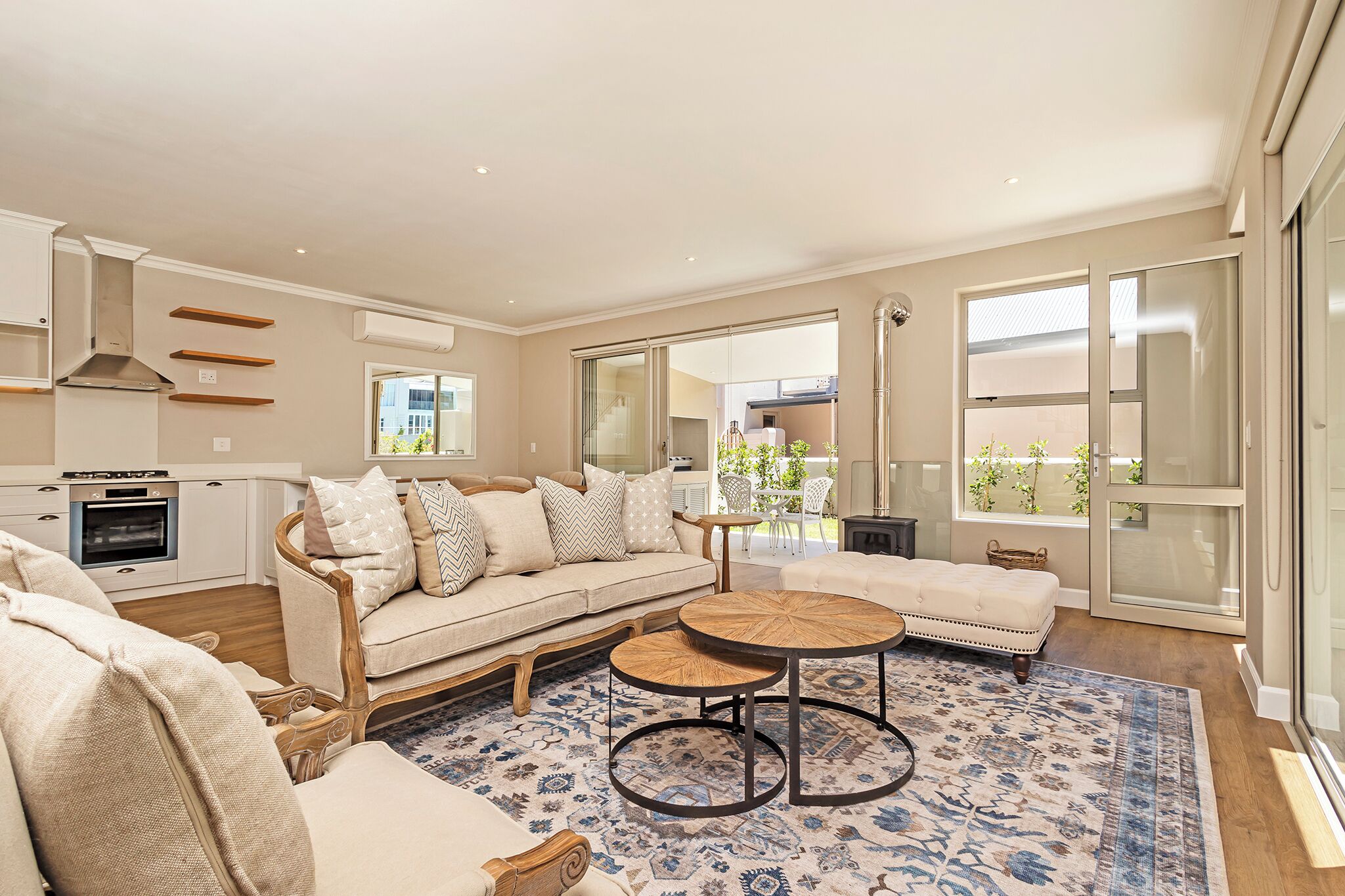 A modern living room with a sofa, coffee table, and a view of the outside.