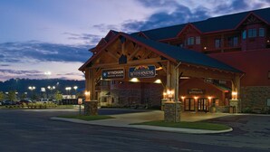 Uma pousada com entrada coberta, placas indicando Wyndham Vacation Resorts e Wilderness at the Smokies, e fachada de pedra.