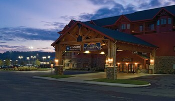 A lodge with a covered entrance, signs for Wyndham Vacation Resorts and Wilderness at the Smokies, and a stone facade.