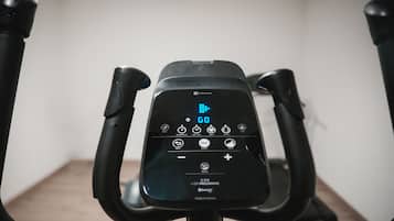 A stationary exercise bike with a digital display and control panel.