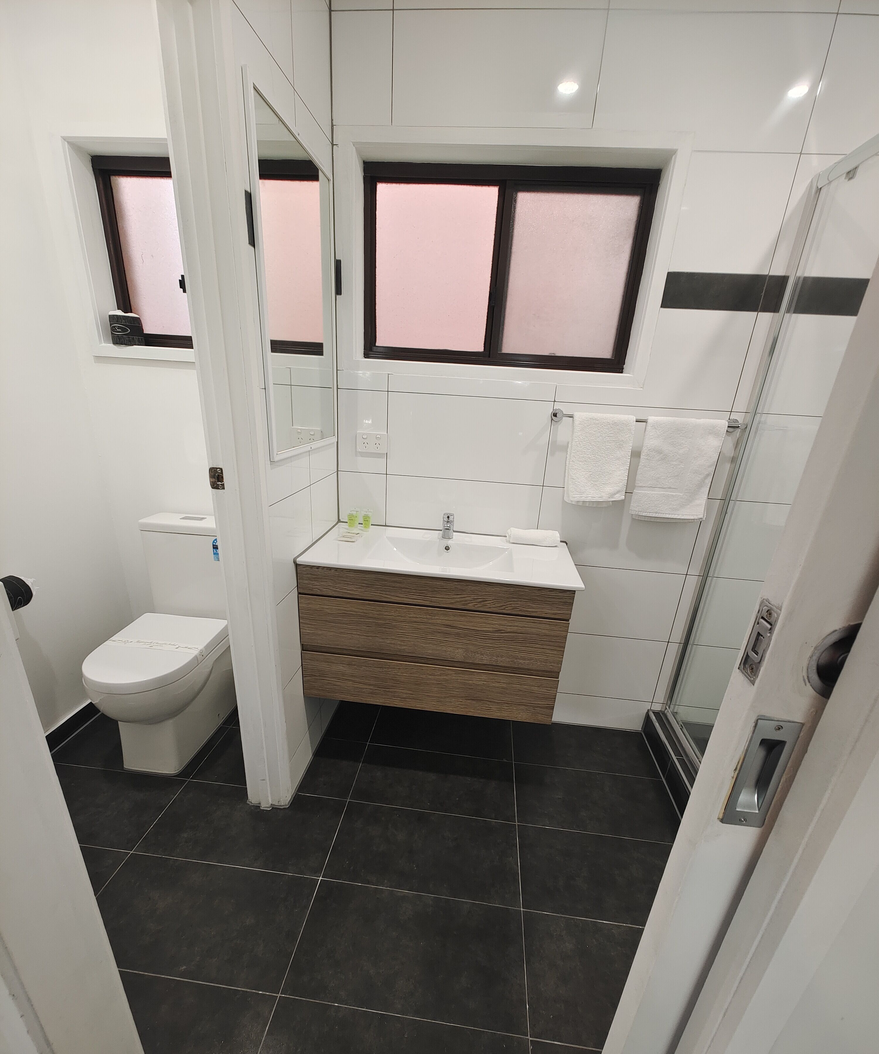 A modern bathroom with a toilet, sink, and shower.
