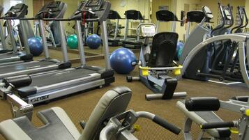 Een sportschool met loopbanden, elliptische trainers en fitnessballen.