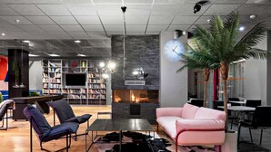 Un área de estar moderna con chimenea, estanterías, un sofá rosa y una mesa de centro.