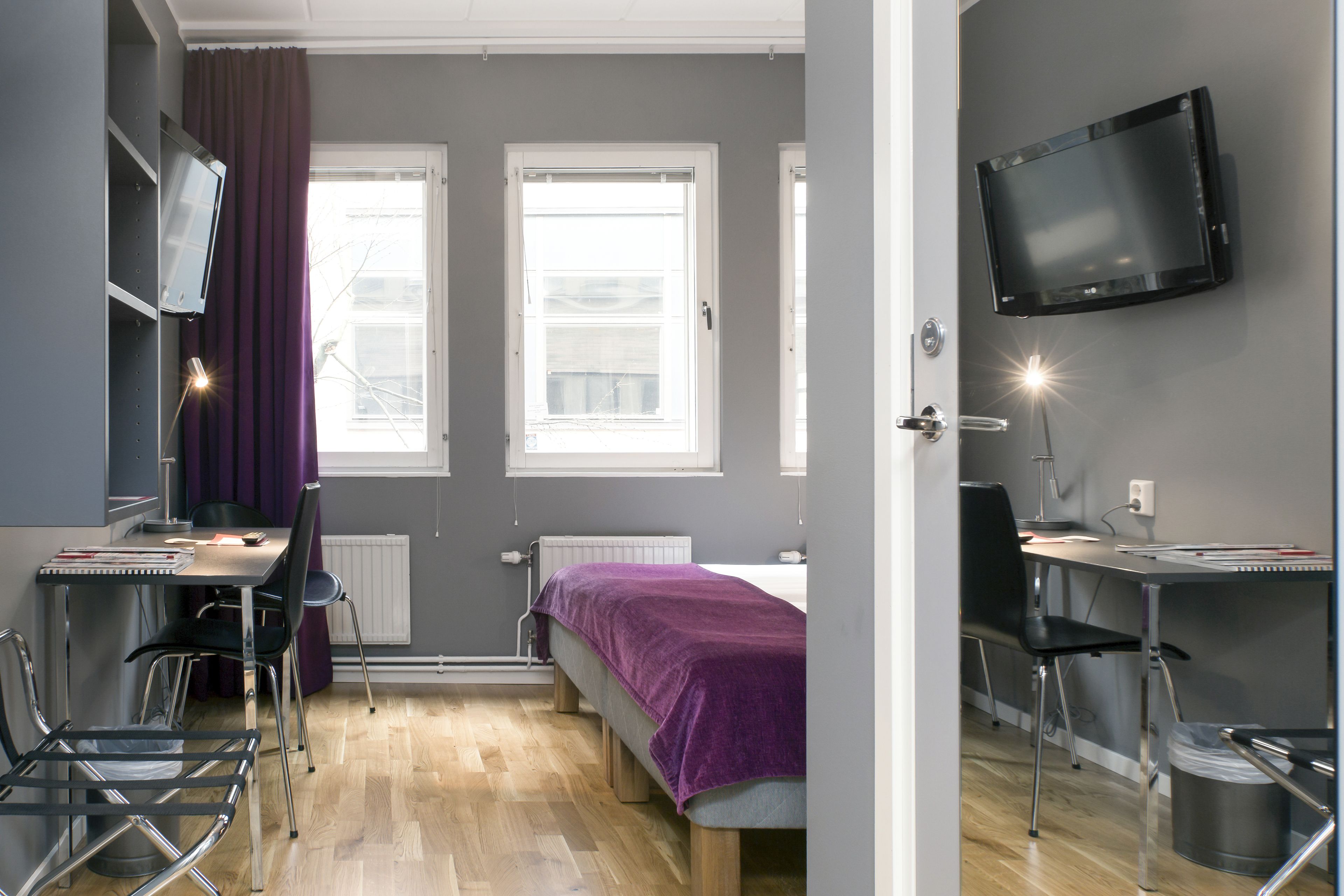 Une chambre à coucher moderne avec un lit, un bureau et un téléviseur.