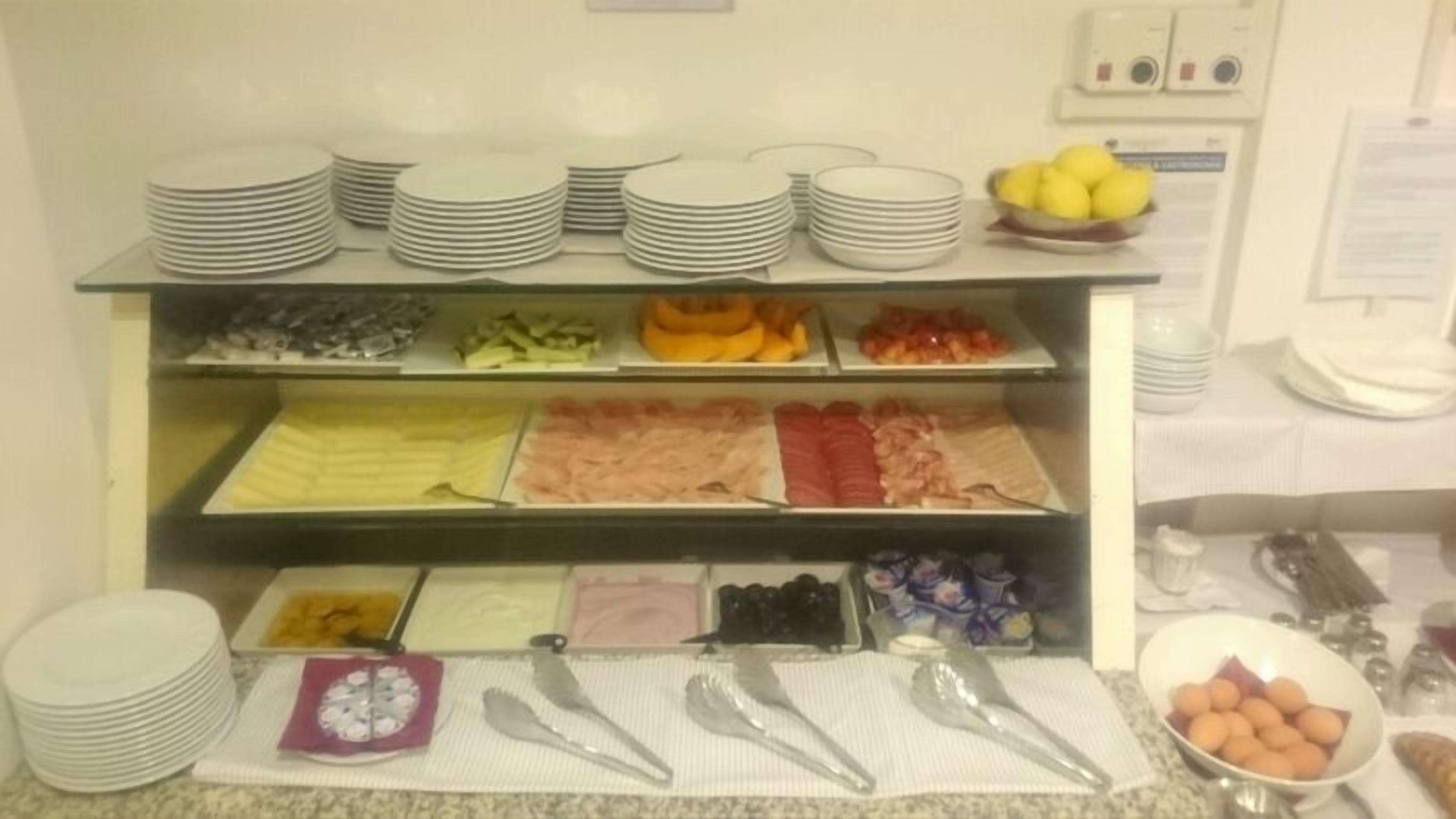 A buffet setup with various food items and serving utensils.