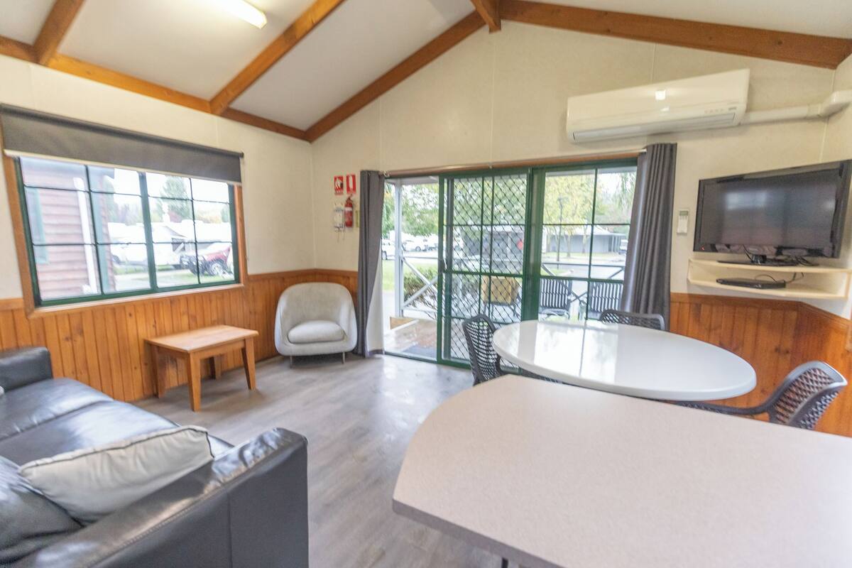 A modern interior with a sofa, a round table, and a TV mounted on the wall.