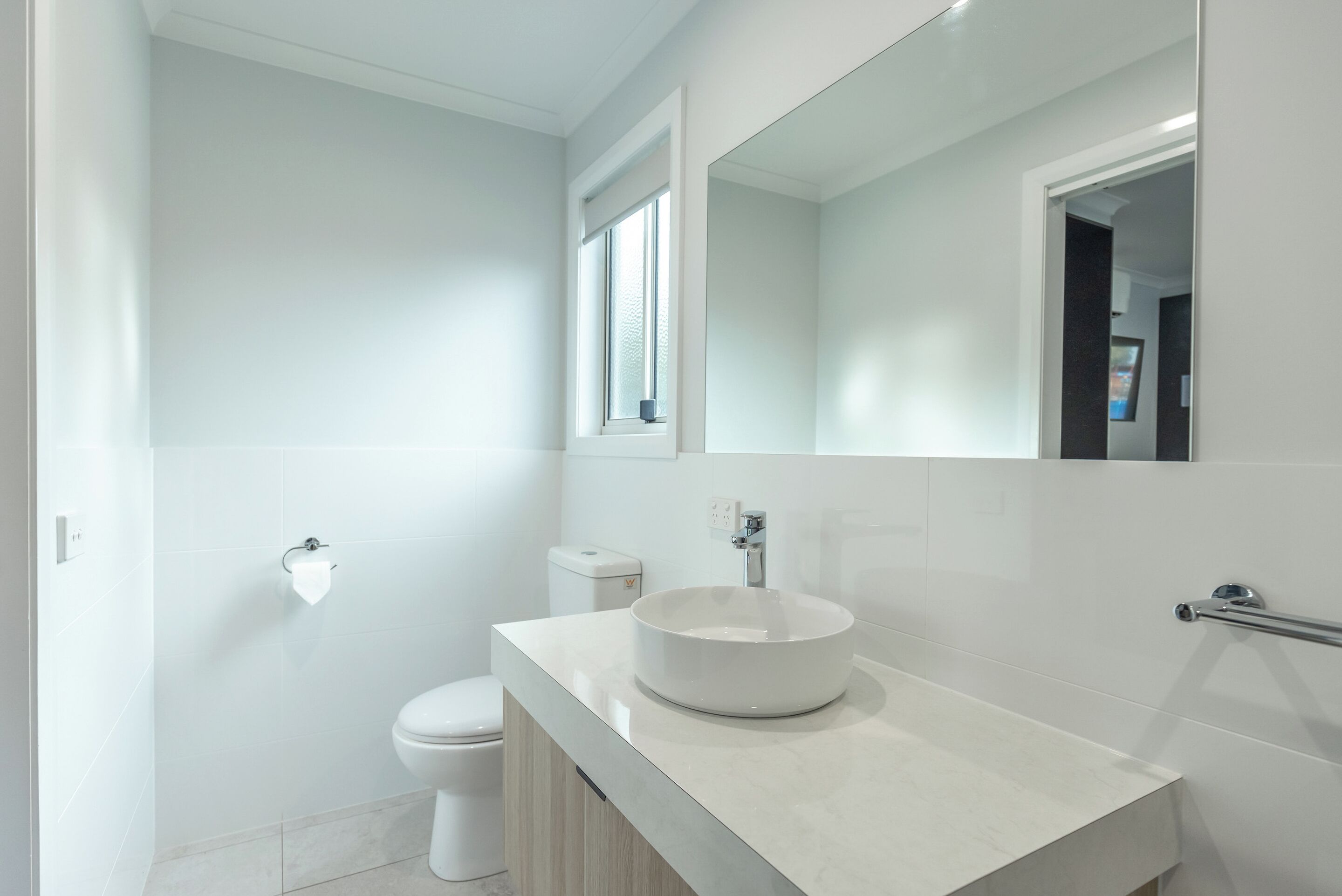 A modern bathroom with a white sink, toilet, and vanity.