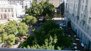 A cityscape with a mix of modern and historic buildings, a central tree-lined square, and outdoor seating areas. - Greenmarket Place Apartments (Cape Town)