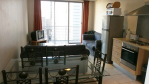 A modern apartment with a dining area, a living room, a kitchen, and a balcony with a city view. - Greenmarket Place Apartments (Cape Town)