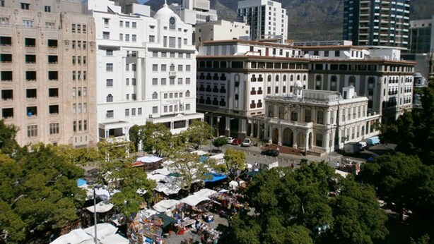 A cityscape with historic buildings, a central plaza, and a mountainous backdrop. - Greenmarket Place Apartments (Cape Town)