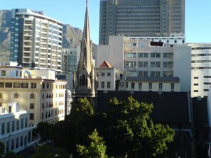 A cityscape with a prominent church spire, modern high-rise buildings, and a mix of architectural styles. - Greenmarket Place Apartments (Cape Town)