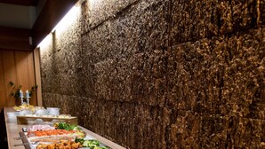 A buffet with various food options, including salads, meats, and rice, arranged on a long table against a textured wall. - Lærdal Hotel (Laerdal)