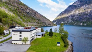 A hotel with a modern design, situated by a lake with mountains in the background. - Lærdal Hotel (Laerdal)