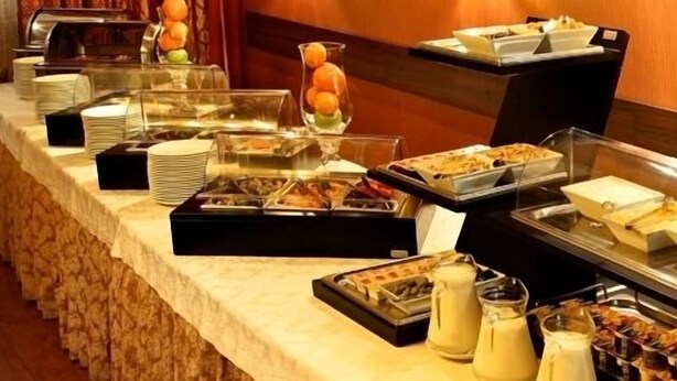 Uma mesa de buffet com diversos alimentos e bebidas.