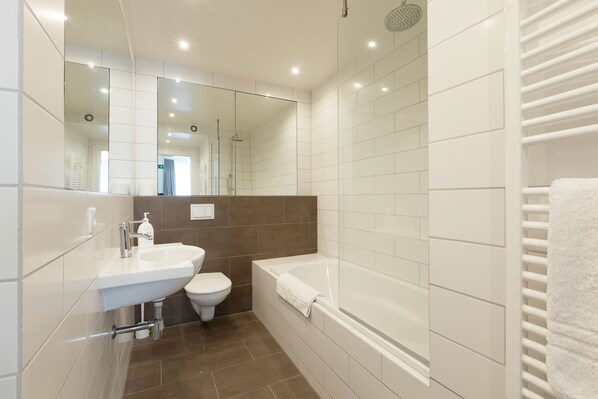 Un baño moderno con lavamanos, inodoro y bañera.