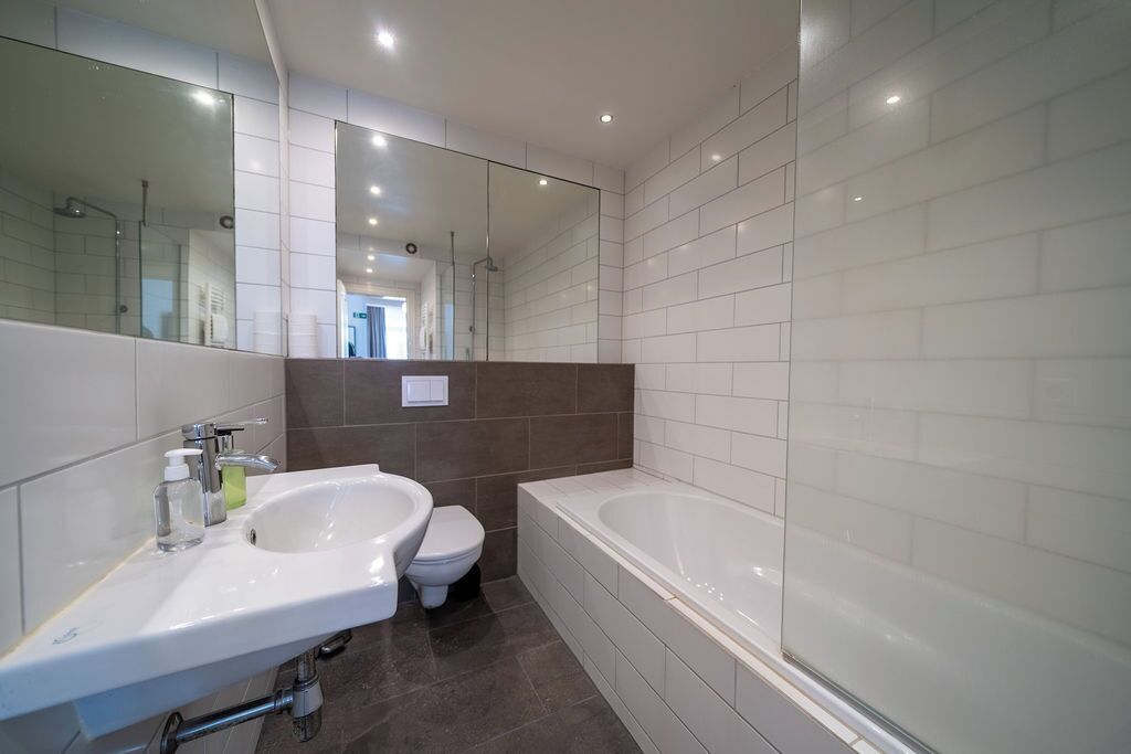 Ein modernes Badezimmer mit Waschbecken, Toilette und Badewanne.