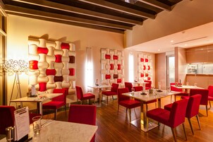 A modern restaurant with red and white decor, wooden floors, and a bright interior.