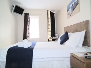 Escritorio, tabla de planchar con plancha, wifi y ropa de cama