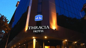 Un moderno edificio de hotel con un cartel llamativo que dice "THRACIA HOTEL".