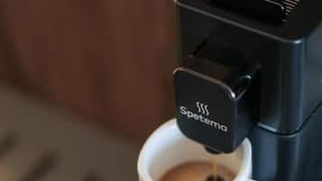 Una máquina de café vertiendo café en una taza con la etiqueta 'Spetema'.