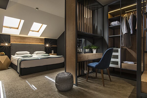Un dormitorio moderno con tragaluz, una cama, un escritorio y un armario.