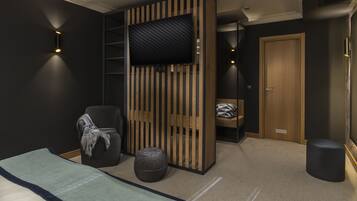A modern bedroom with a bed, a TV mounted on a wooden panel, a chair, a small round ottoman, and a wardrobe with a mirror.
