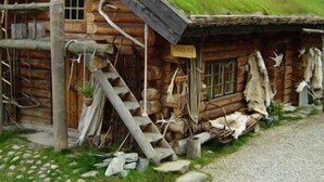 A log cabin with a grass roof, a wooden ladder, and a sign on the door. - Engholm Husky Design Lodge (Karasjok)