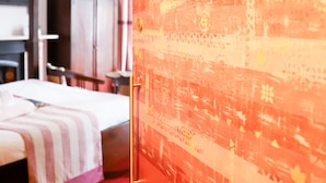 A hotel room with a bed, a door with a number plate, and a wall with a textured design. - The Cavalaire (Brighton)