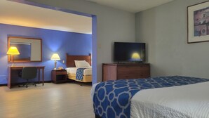 A hotel room with a bed, a desk with a chair, a television, and a desk lamp. - Baymont by Wyndham Hannibal (Hannibal)
