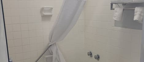 A bathroom with a bathtub, toilet, and a shower curtain.