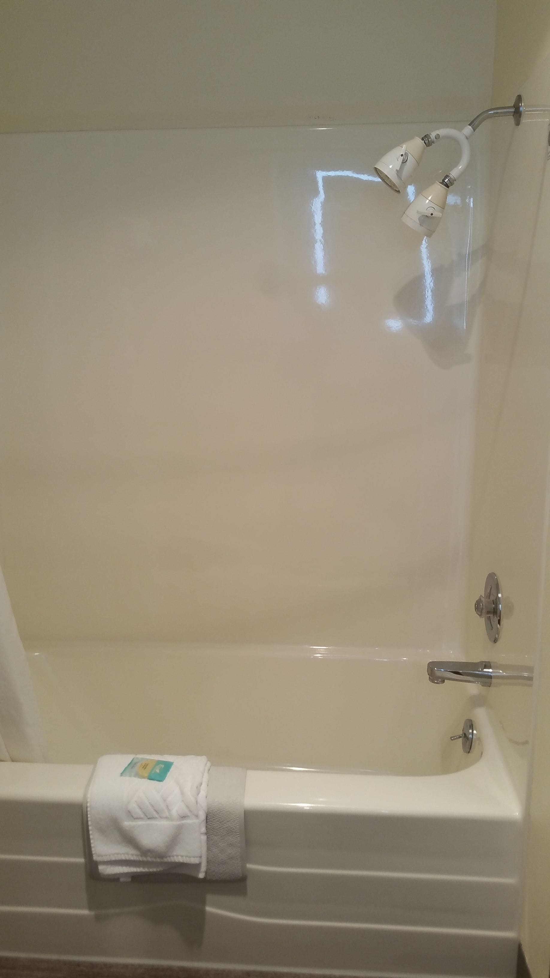 Una bañera con una toalla y un cabezal de ducha.