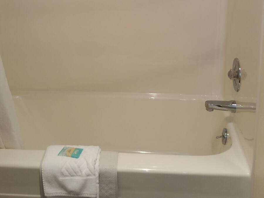 A bathtub with a towel and a shower head.