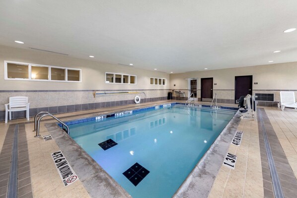 Una piscina con carriles claramente delimitados, una silla para salvavidas y una zona de vestuarios.
