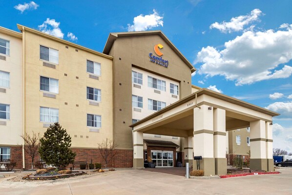 A Comfort Inn with a beige facade, a covered entrance, and a parking lot.