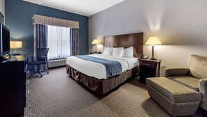 A hotel room with a large bed, two bedside lamps, a desk with a chair, and a sofa. - Comfort Inn & Suites Oklahoma City West - I-40 (Oklahoma City)