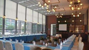A conference room with long tables, chairs, and a projector screen. - Intl Talent City Hotel (Shanghai)