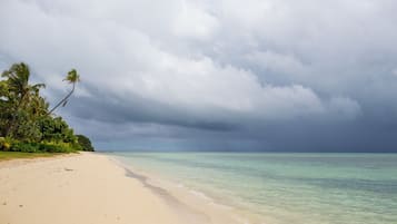 Playa privada, arena blanca, sillas reclinables de playa, sombrillas