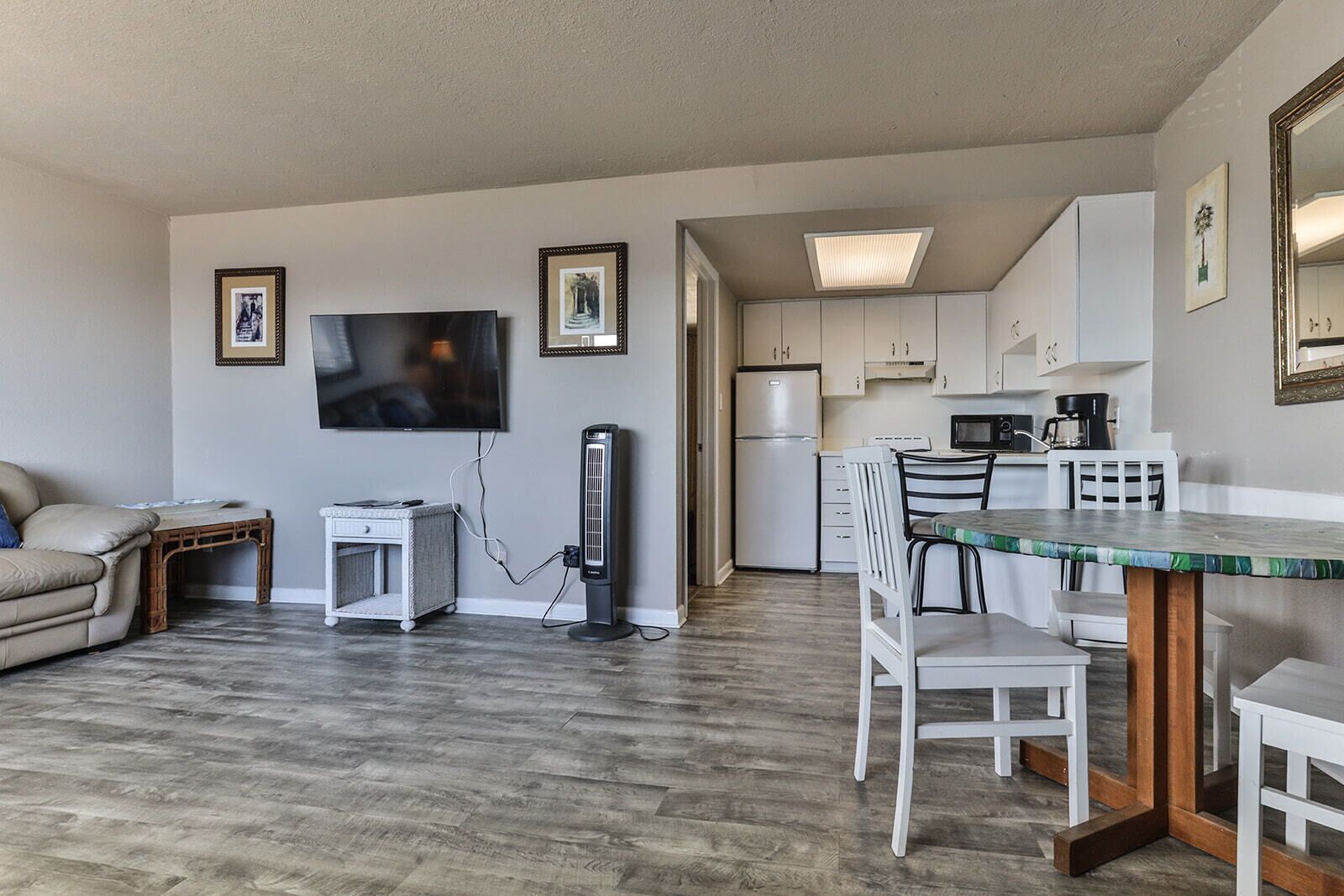 A compact living space with a kitchenette, a dining area, and a seating area with a television.