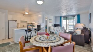 A compact living space with a kitchen, dining area, and seating area. - Coastal Waters Inn (New Smyrna Beach)