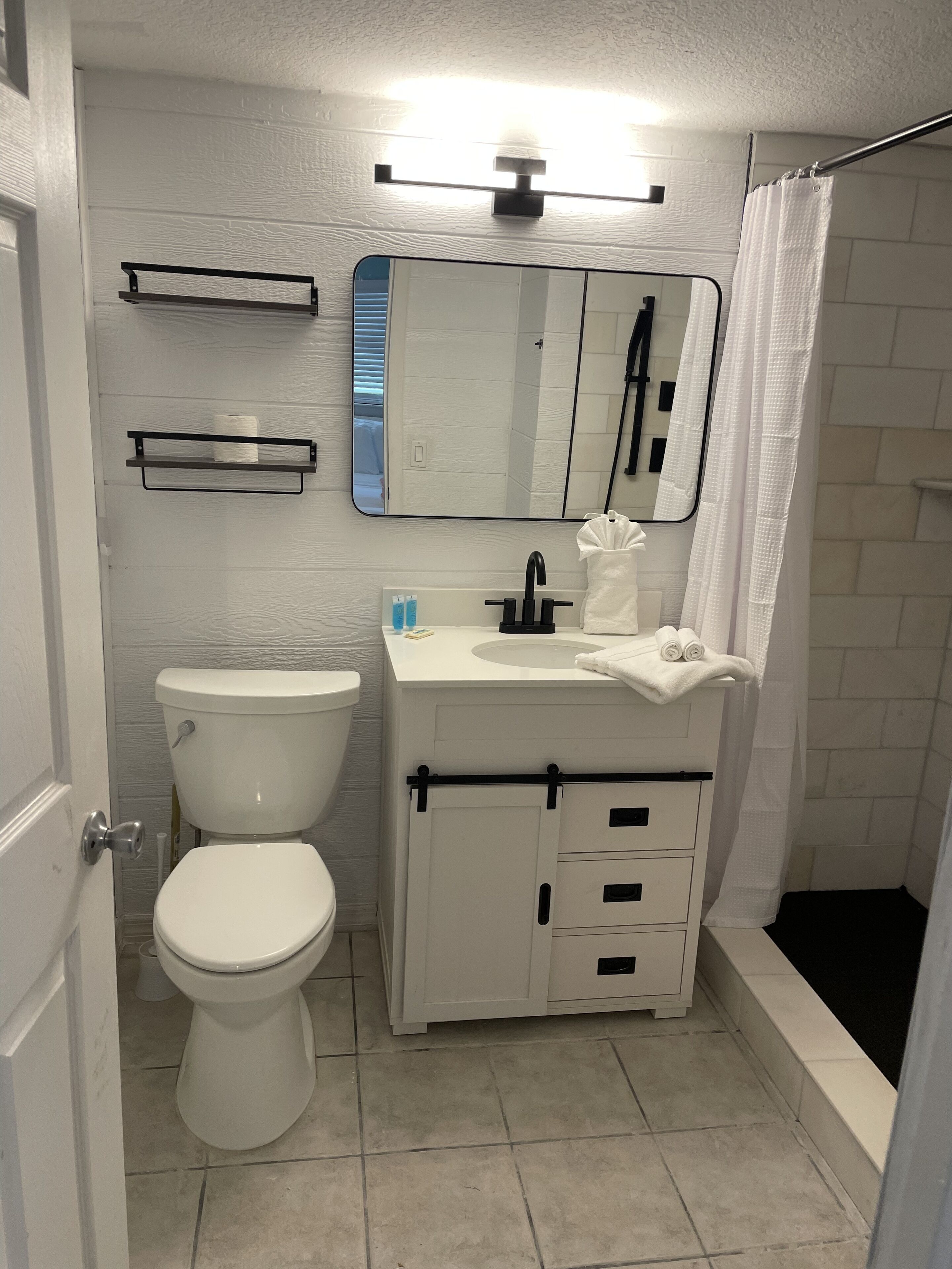 Un baño con inodoro, lavamanos y ducha.