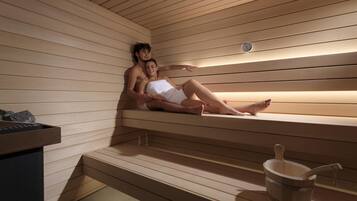 Een sauna met houten banken, een emmer en een klok aan de muur.