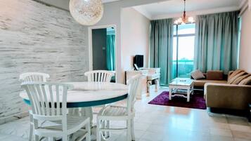Una sala de estar moderna con comedor, un sofá y una televisión.