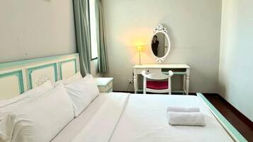 Habitación de hotel con cama, escritorio con espejo, lámpara y ventana con cortinas.