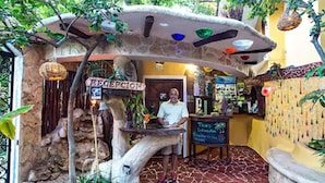 A reception area with a stone archway, a reception desk, and a sign that reads "RECEPTION". - Maison Tulum (Tulum)