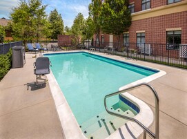 Una piscina al aire libre de temporada, sombrillas