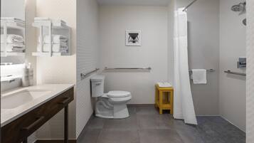 A modern bathroom with a toilet, sink, and shower area.